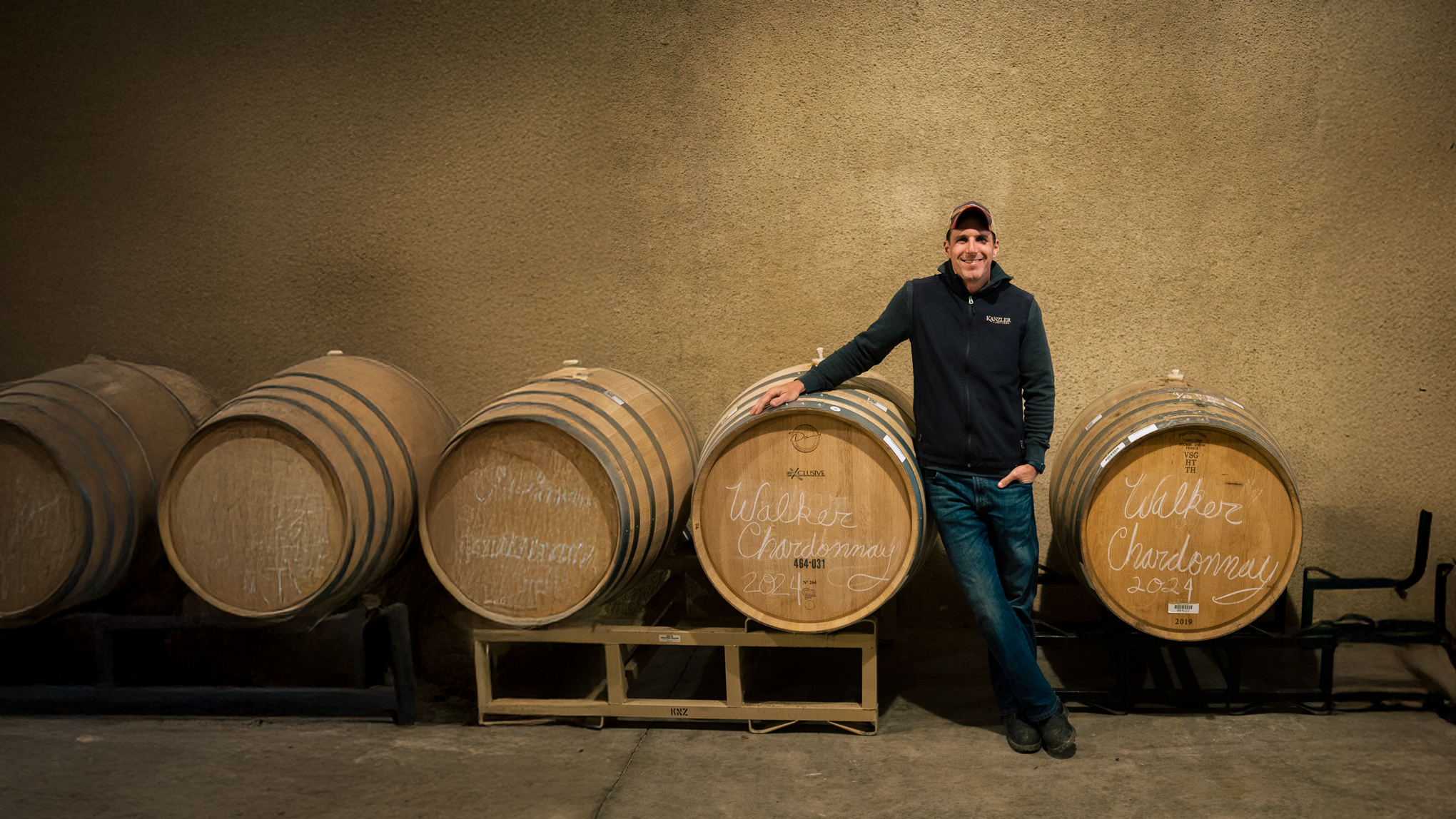 Alex Kanzler standing in the cellar next to barrels